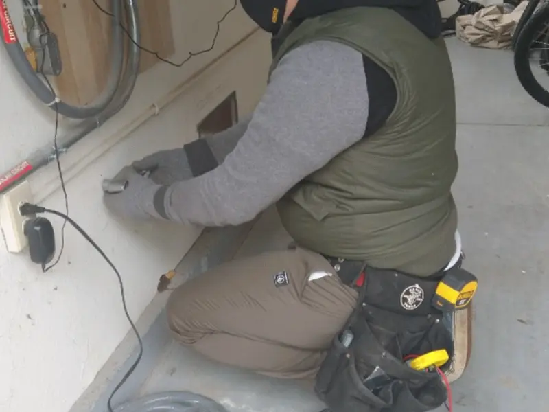 Electrician performing outlet wiring in a Fox River Grove garage